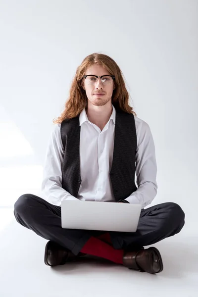 dizüstü bilgisayar ile katta oturan Kızıl saçlı şık dövmeli işadamı