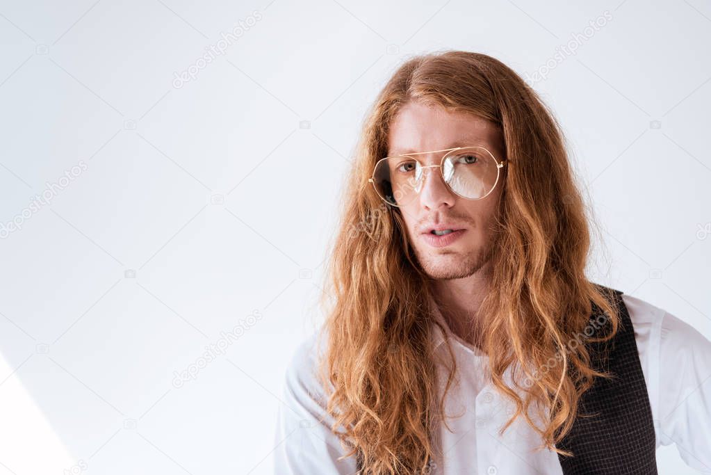 portrait of stylish businessman with curly ginger hair on white