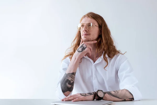 Pensoso elegante uomo d'affari tatuato con i capelli ricci guardando lontano isolato su bianco — Foto stock