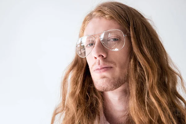 Retrato de hombre guapo con pelo rizado de jengibre y gafas mirando a la cámara aislada en blanco - foto de stock