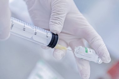 Bir hemşirenin elleri şırıngaya ilaç alır.