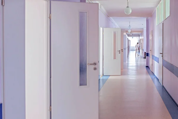 hospital corridor with open doors to wards and a nurse bypass