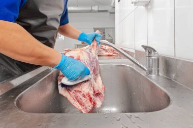 Et işleme fabrikası, kasap et yıkıyor.