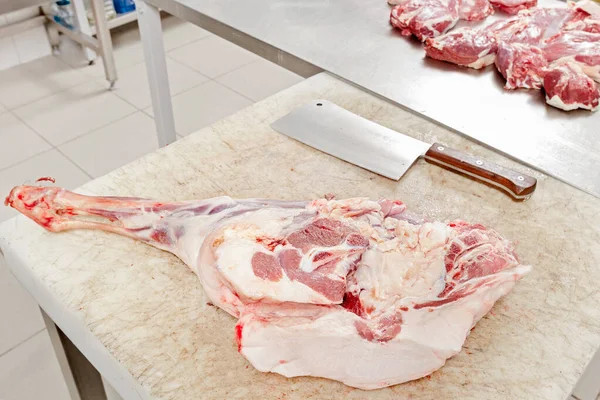 Meat processing plant, meat leg on a cutting table