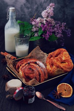 Bahar kahvaltısı. Taze pişmiş kruvasan, masada bir demet leylak ve süt.