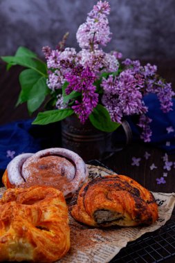 Bahar kahvaltısı taze kruvasan ve masada bir buket leylak..