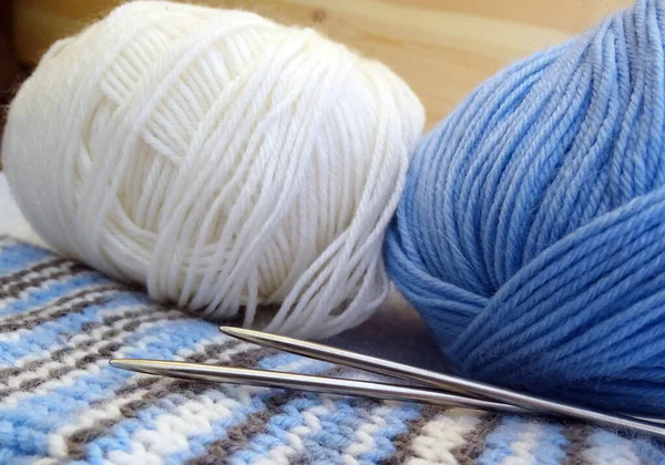 Синяя и белая вязальная шерсть и вязальные шприцы — стоковое фото