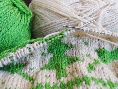 Örgü iğnelerinde bitmemiş bej süveter