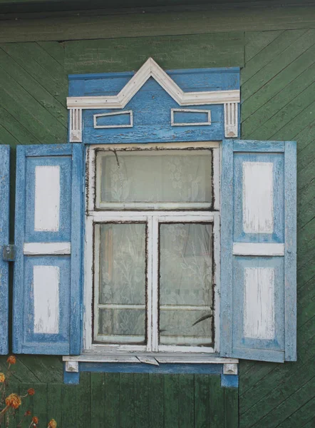 Ventana con persianas de madera tallada en una casa rusa — Foto de Stock