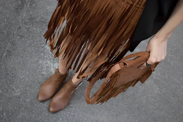 Brown fringe skirt and brown leather bag and shoes in style of boho. Fashion and stylish concept.