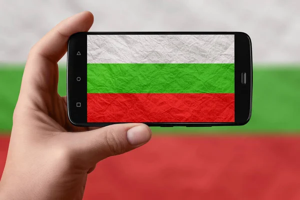 Bulgaria flag on the phone screen. Smartphone in hand photographing flag.