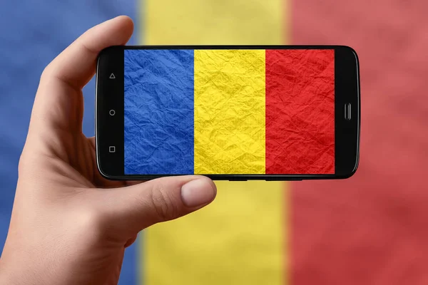Flaga Rumunii na ekranie telefonu. Smartfon w ręku fotografowania flagi. — Zdjęcie stockowe