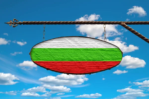 Bulgaria flag on signboard. Oval signboard colors Bulgaria flag hanging on a metal forged structure. Template on a background of blue sky with clouds.