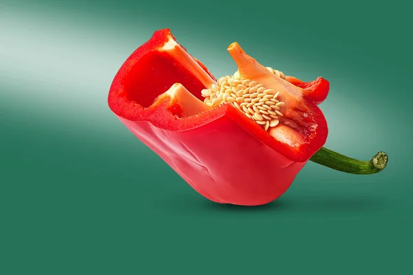 Pimiento rojo con semillas. Cortar el pimiento en forma de flor de tulipán sobre un fondo verde. Alimentos ecológicos . — Foto de Stock