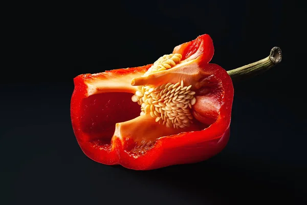 Κόκκινη πιπεριά με σπόρους. Άνοιξε πιπεριές σε μαύρο φόντο. Βιολογικά τρόφιμα. — Φωτογραφία Αρχείου