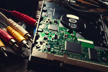 Closeup of computer and wire detail. Old computer hard drive and cables. Microchips and PC components, storage data and information recovery.