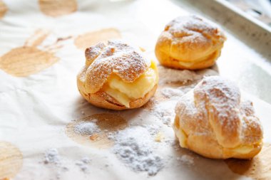 Ev yapımı pişirme. Taze pişmiş sıcak çörekler üzerine pudra şekeri serpiştirilmiş ve kabartma kağıdına istiflenmiş..