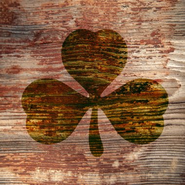 St. Patrick's Day. Dark stain in the shape of a three-leaf clover on a wooden surface. 