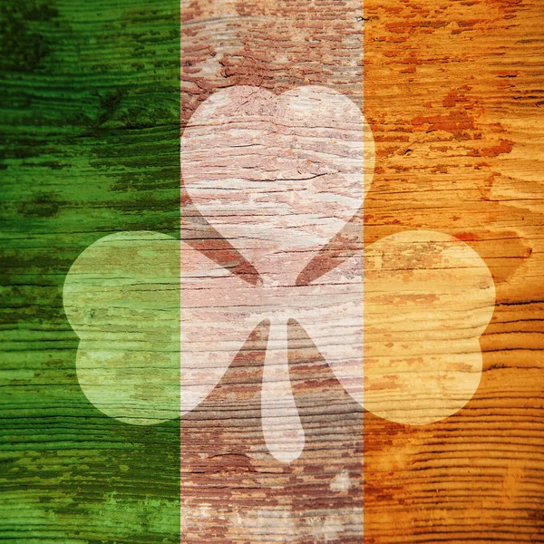 Saint Patrick. Spot lumineux en forme de trèfle sur la surface en bois des couleurs du drapeau irlandais . — Photo