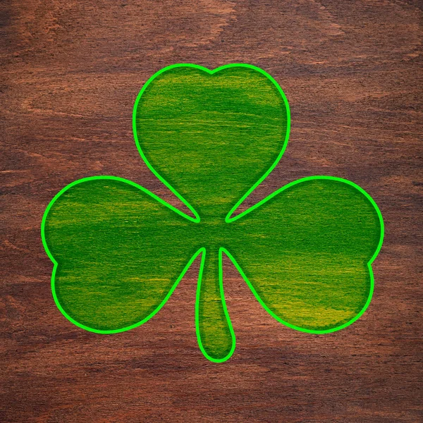 St. Patrick's Day. Light green shamrock is painted on a wooden surface. Three leaf clover. — Stock Photo, Image
