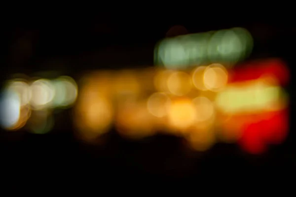 Bokeh signboards and shop windows. Blurred image of neon light in a shop window at night in the city. Bokeh elements. Creative background for montage and design.