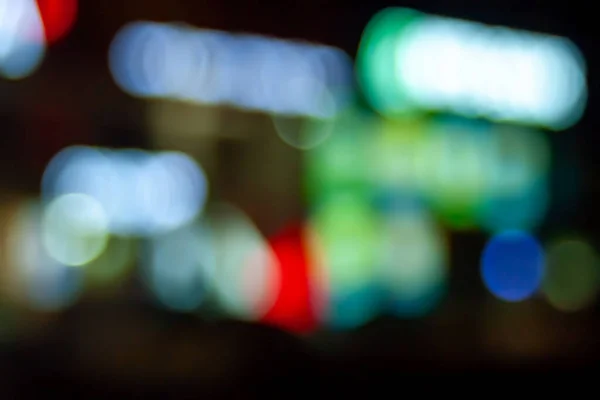 Bokeh signs and shop windows. Blurred image of neon light in a shop window at night in the city. Bokeh elements. Creative background for montage and design.