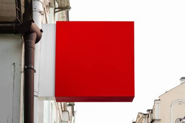 İmza panosu modeli. Evin duvarında kırmızı kare tabela dükkanı var. Yaratıcılık ve tasarım için düzen.