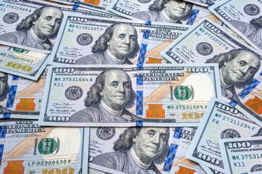 Yüz dolarlık banknotlar. Birçok banknot masaya saçıldı. Bir tomar Amerikan doları. Para dokusu. Bankacılık ve finansal konsept.