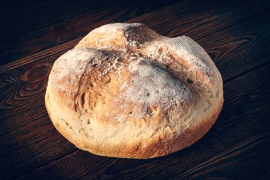 Ev yapımı ekmek. Tahta arka planda buğday ekmeği. Ev yapımı pişirme. Tonu ayarlanmış resim.