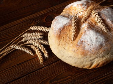 Ev yapımı sıcak ekmek. Yuvarlak Köfte Köylü ekmeği ve ahşap arka planda buğday kulakları. Ev yapımı pişirme.. 