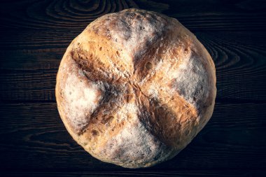 Ev yapımı taze ekmek. Tahta arka planda buğday ekmeği. Ev yapımı pişirme. Tonu ayarlanmış resim.