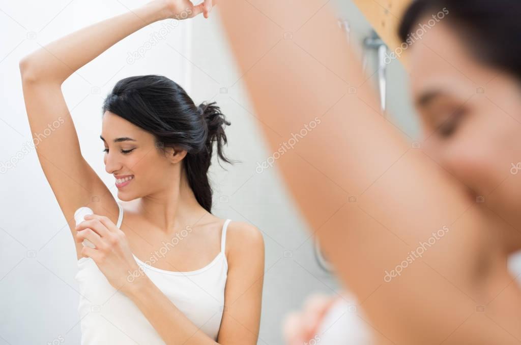 Woman using deodorant stick