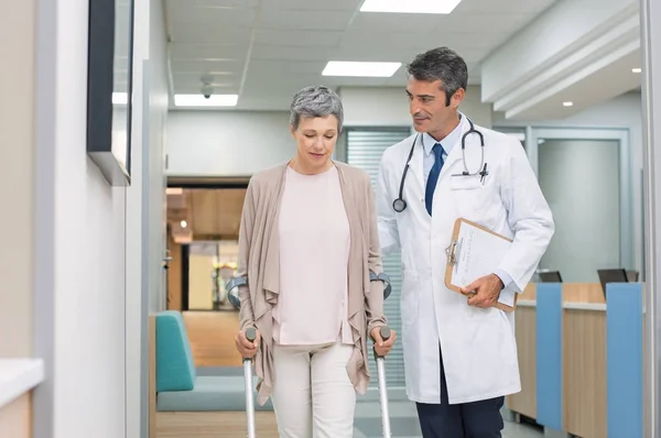 Arzt und Patient mit Krücken — Stockfoto