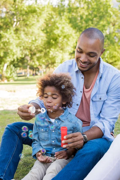 Padre e hijo soplando burbujas — Foto de Stock