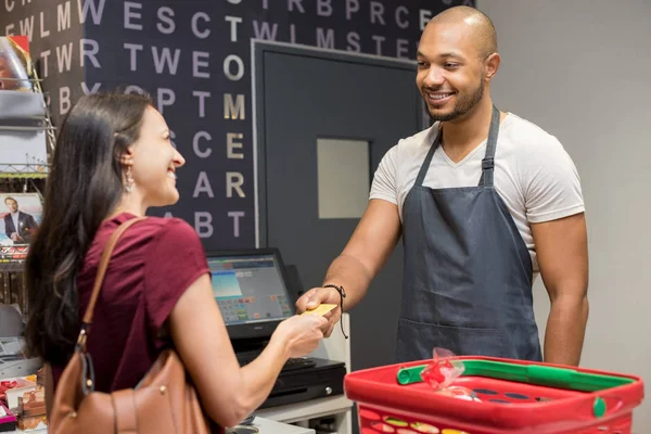 Vrouw betaalt bij supermarkt — Stockfoto