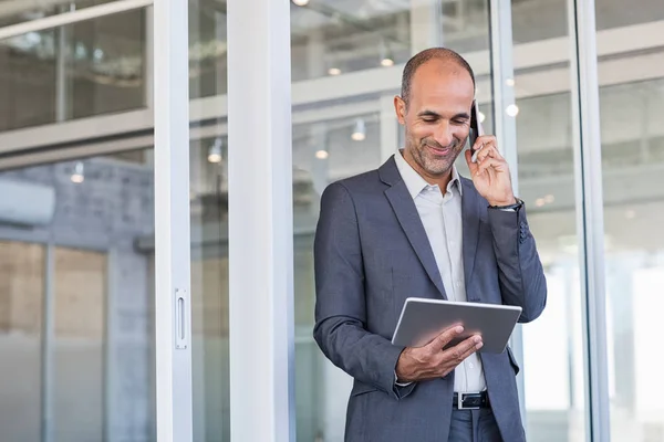 Empresário usando tablet e telefone — Fotografia de Stock