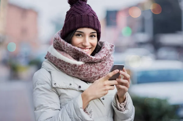 Mulher de inverno mensagens de texto no telefone — Fotografia de Stock