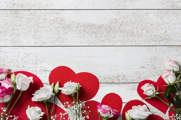 Květiny na Valentýna na dřevěné pozadí se srdíčky — Stock fotografie