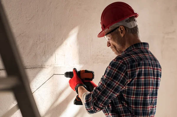 Man borra hål i väggen — Stockfoto