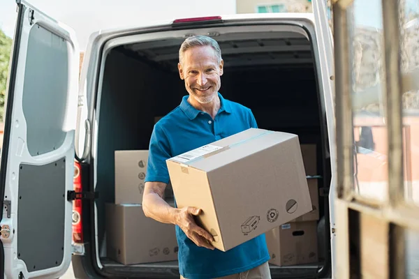 Zusteller hält Paket — Stockfoto