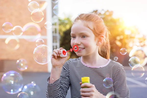 Menina bonito jogando com bolhas de sabão — Fotografia de Stock