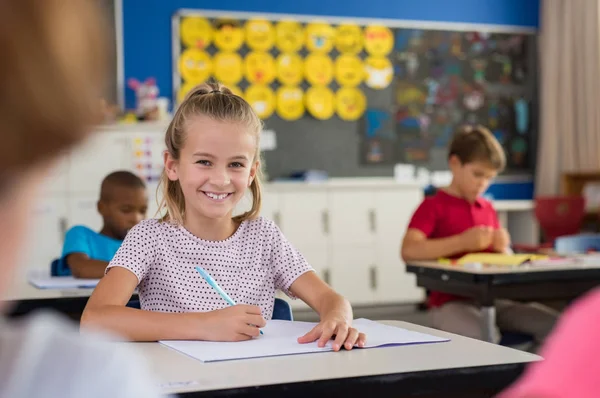 微笑的学校女孩做笔记 — 图库照片