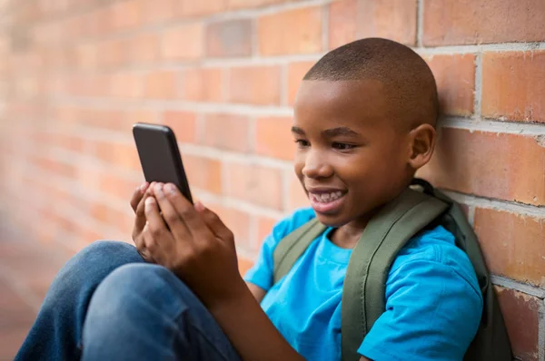 Jongen van de school met behulp van slimme telefoon — Stockfoto