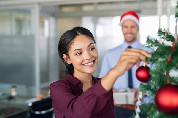 Zakenvrouw versieren kerstboom op kantoor — Stockfoto