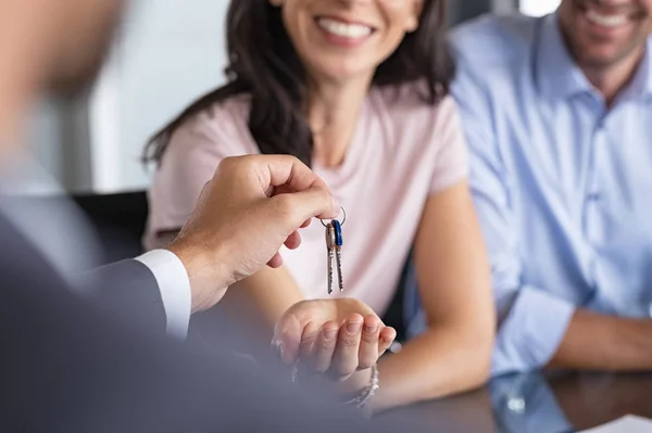 Fastighetsmäklare som ger husnycklar till kvinnan — Stockfoto