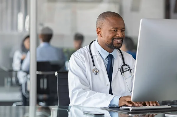 Africano maduro médico trabalhando no computador — Fotografia de Stock