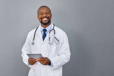 Smiling doctor standing on grey wall clipart