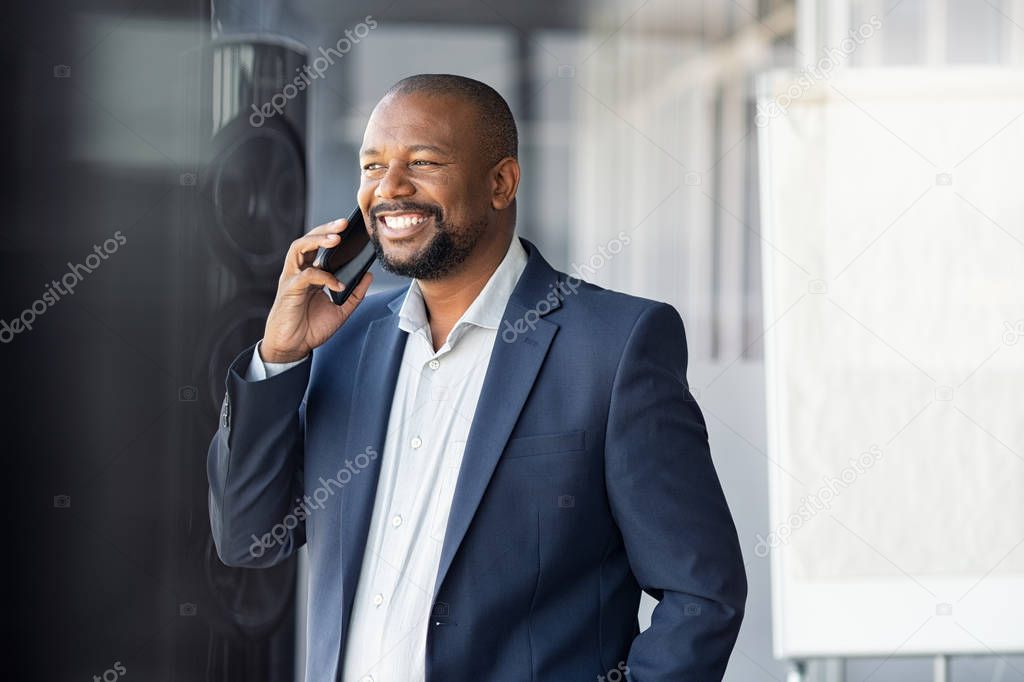 African mature businessman talking over phone