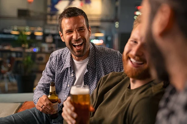 Друзья наслаждаются пивом в пабе — стоковое фото
