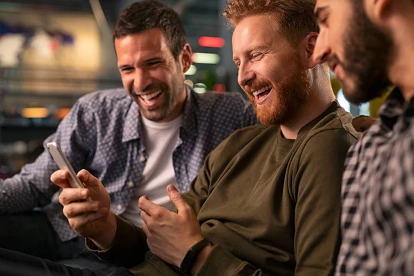 Amigos riendo y usando smartphone en el pub —  Fotos de Stock